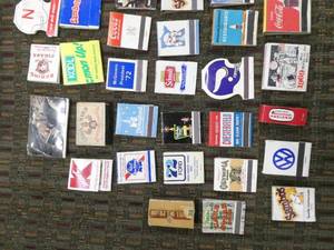 lot 54 image: Box of collectible matchbooks including Nixon, Olympia beer, Chesterfield cigarettes, Schmidt beer, Twins, Vikings, Mash, Coke, Mt Rushmore, Man on the moon, Lucky Strike
