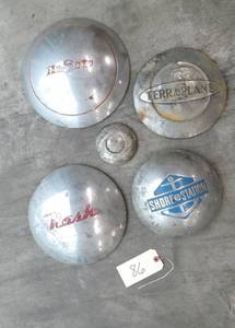 lot 86 image: Group of 5 collectible wheel covers - Nash, DeSoto, Terraplane, Shore Station, Ford