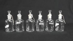 lot 83 image: Set of 6 Vintage T.C.W. Company 125 ML Glass Dropping Bottles With Unique Stoppers