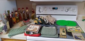 lot 62 image: Assortment of Kitchen Decor Vase, Hotplate, Wall Decor, Trivets, Towels, Oven Mitt and More 