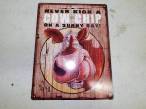 lot 20 image: Sure to Get a good Laugh Never Kick a Cow Chip Metal Sign