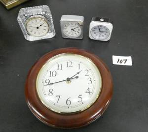 lot 107 image: Clocks galore - 2 travel alarm clocks, a wall clock and a desk clock - all work