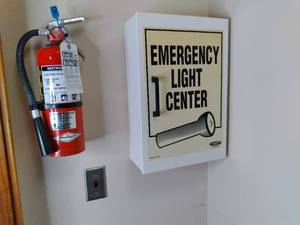 lot 770 image: Wall Mounted Emergency Light Center Cabinet, Fire Extinguisher, and Other Items