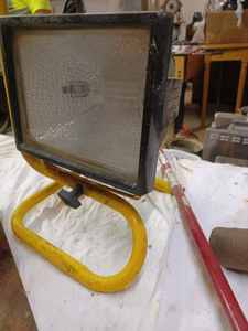 lot 65 image: Halogen Shop Light, Grease Gun, Ladder Hanger, Dog Chain Anchor, and a Trailer Tire WheelSpindle