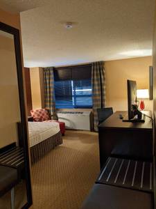lot 143 image: Room 1014. King bed, TV 42 LG, Dresser, Nightstands, Luggage Bench, Small Safe, Chair, Ottoman, Desk, and More