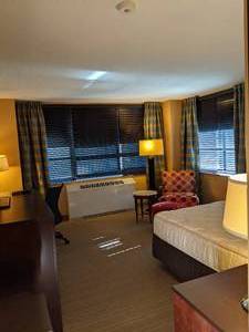 lot 149 image: Room 1020. King bed. Stone top table, Mini Fridge, Small Safe, TV 42 LG, Lamps, Mirrors, Desk, Chair, and More