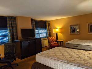 lot 144 image: Room 1016. 2 Full beds. Stone top side table, TV 42 LG, Chair, Ottoman, Desk, Lamps, Mirrors, and More
