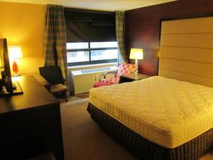 lot 159 image: Room 907. King bed, Curtains, Mini Fridge, LG TV, and more