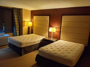 lot 25 image: Room 1501. 2 Full beds, Luggage Bench, Artwork, Pedestal Sink and More