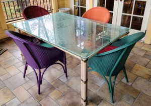Amazing Glass Topped Dining Table and Colorful Wicker Chairs
