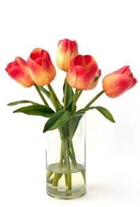 Glass vase of realistic artificial tulips in clear medium