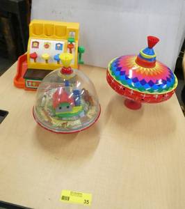 A vintage spinning top with horse and wagon and horse pulling a log that run around the old mill, a current spinning top and a fisher price cash register