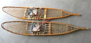 A pair of Snocraft wood and leather snow shoes (I see in this picture I paired them up incorrectly, they look so much the same, but you will get an actual pair of Snocraft)
