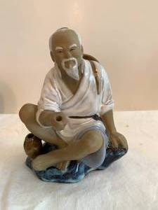 Happy Fisherman, carved disc on stand