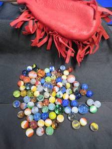 lot 16 image: VINTAGE RED LEATHER MARBLE BAG FULL OF MARBLES