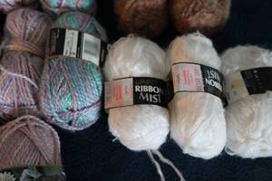 lot 15 image: Thirteen Skeins Of Miscellaneous Brands & Colors Of Yarn--(Ribbon Mist---Fanfare Unger)