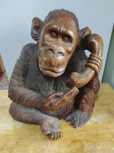 lot 1 image: Hand Carved Wood Orangutan Using Telephone