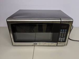 lot 136 image: Oster 1.1 Cu. Ft. 1000-Watt Countertop Microwave Oven with Stainless Steel Front