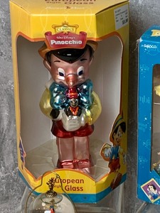 lot 92 image: Three Pinocchio Themed Christmas Ornaments and a Miniature Snow Globe