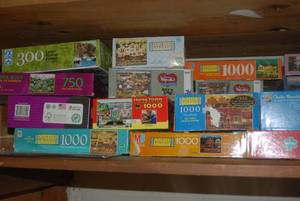 Shelf of puzzles (see photos )...