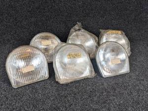 lot 1645 image: NOS - (Lot of 6) 1968-69 Suzuki T10, 150, S32-2 Sealed Beam Lenses - Part No. 35121-09610 - Some of the rings have rust