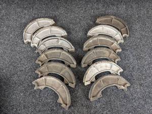 lot 1663 image: NOS - (Lot of 12) 1967-69 Suzuki T10, T20, TC250, T305, TC305 & 1972 T250 Brake Shoes - Part No. 54410-11000