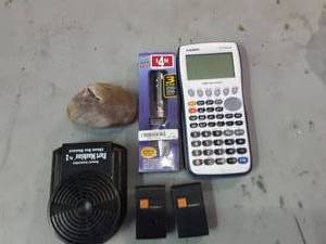 lot 50 image: Casio FX9750GII Graphing Calculator, Laser Pen, Fart Machine, Rock