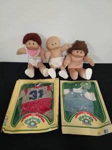 lot 43 image: Three Cabbage Patch Dolls and Two Outfits