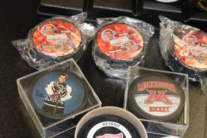 lot 34 image: Commemorative Hockey Puck Resale Lot  10 Pucks  Stand
