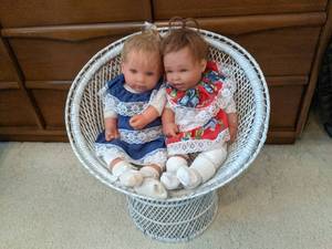 2 porcelain babies in a white wicke...
