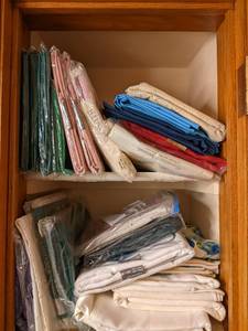 2 shelves of table cloths, several ...