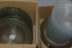 lot 104 image: 5 boxes of an assortment of items including glass plates, disposable plates misc light sets, measuring tools,cupcake scirting, ribbon, gift wrap & gift wrap cutter and much more
