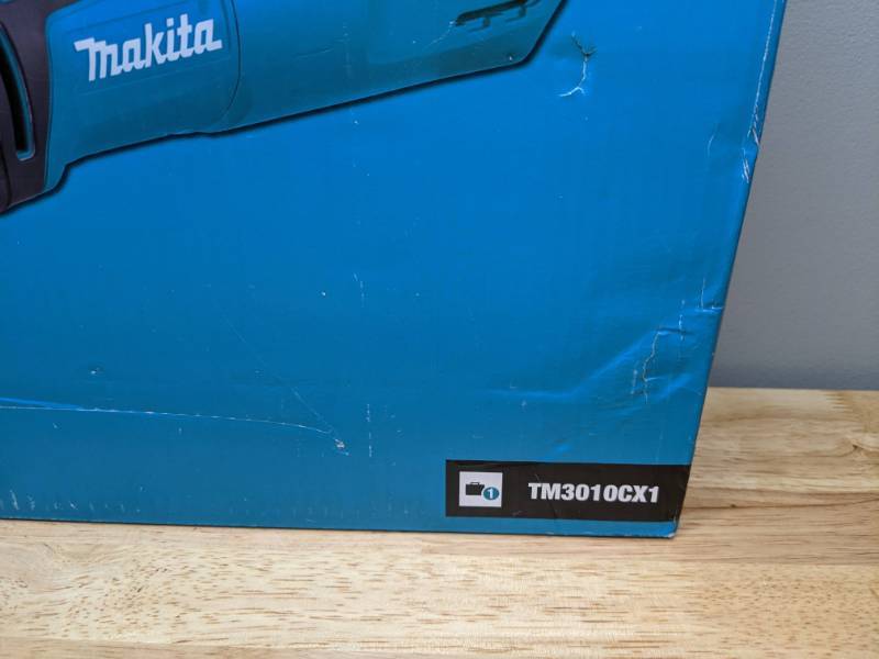 lot 117 image: Brand New Makita 3 Amp Corded Variable Speed Oscillating Multi-Tool Kit With Blade, Sanding Pad, Sandpaper, Adapter, Hard Case - T