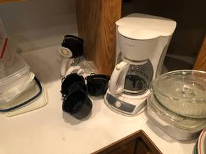 Coffee maker and plates and lots of kitchen utensils.