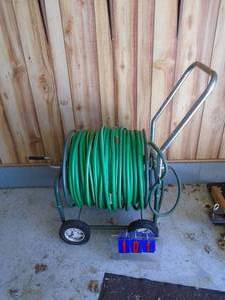 Large hose reel with rubber hose. Approx 100 or more As shown.