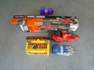 Black & Decker cordless hedge trimmer. No batterycharger, gloves & garbage bags. As shown.