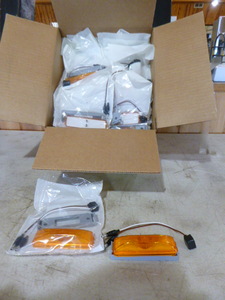lot 56 image: Case of Peterson Manufacturing Amber Marker Lights