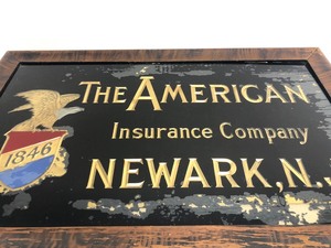 lot 121 image: Antique THE AMERICAN Insurance Company Reverse on Glass Advertising Sign