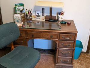 lot 86 image: Small Wood Desk and Contents Floor Mat, Desk Chair, Garbage Can, Lamp, and more