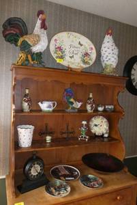 lot 19 image: Contents of all the shelves of the buffet  Includes large rooster and hen pair, platter, plates, bowl, clock, and other dcor