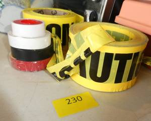 lot 230 image: Caution tape rolls, electrical tape, disposable gloves and safety glasses