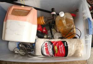 lot 322 image: Tote of misc items, plastic sheeting for painting, 5 chain saw blades, grease guns, lamp, saw blade, funnel, extension cords, , hydraulic jack, minnow bucket and tiki torch fuel