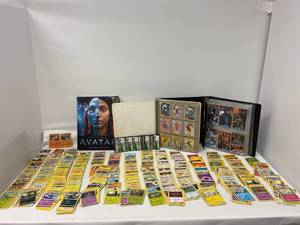 Group of trading cards, Pokemon and Batman and The making of Avatar book