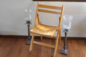 2 large palm tree candle holders and a folding wooden chair