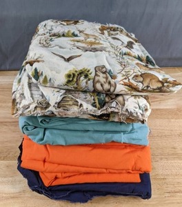 lot 322 image: Stack of Four Different Fabrics (Outdoor Animals, Solids Blue Green, Orange, Dark Blue) - Z