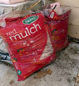 4 bags of Red Mulch, each covers 2 cubic feet (behind house)