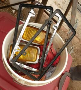 Lot of fog lights, license plate holders, shop rags