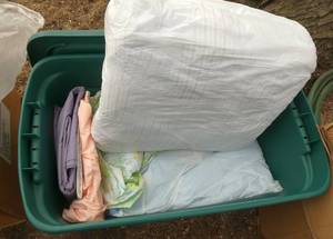 Green tote full of linens and electric blanket