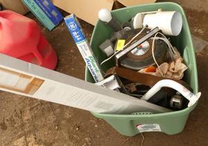 Tote full with a rainbow vacuum, window blinds, motion lights, grab bar, aquarium light, box of gloves