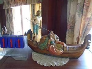 lot 111 image: Couple in plasterceramic gondola. Approx. 24 long. As shown.